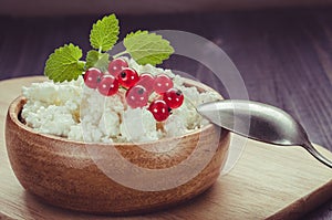 Breakfast: cottage cheese with red berries and mint in a wooden