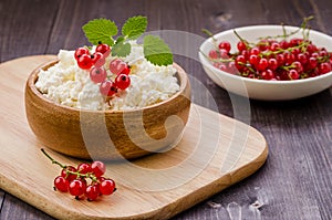 breakfast: cottage cheese with red berries and mint in a wooden