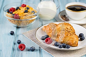 Breakfast with croissant, cereal, berries and fresh coffee
