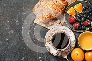 Breakfast with croissant, coffee, orange juice and berries