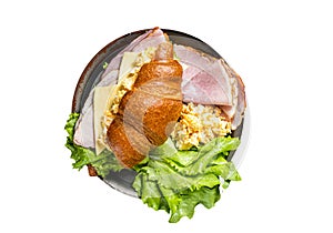 Breakfast croissant sandwich with scrambled eggs, cheese and ham. Isolated on white background.