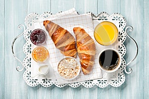 Breakfast with croissants, coffee, jam, orange juice and muesli