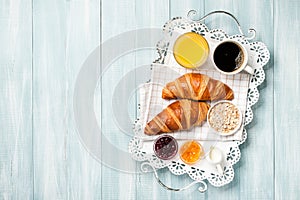 Breakfast with croissants, coffee, jam, orange juice and muesli