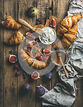 Breakfast with croissants, honey, ricotta cheese, fresh berries and prosciutto