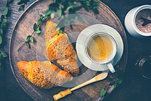 Breakfast - Croissants with nuts and cup of coffee on morning table