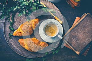 Breakfast - Croissants with nuts and cup of coffee on morning table