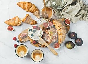 Breakfast with croissants, ricotta, coffee and berries over white background