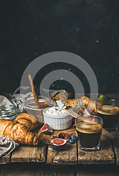 Breakfast with croissants, ricotta, prosciutto, coffee and berries, copy space