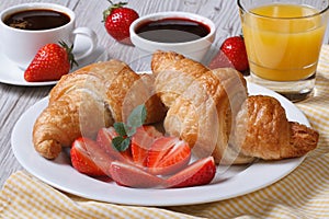 Breakfast: croissants with strawberries and coffee, juice