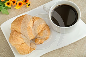 Breakfast with cup of black coffee and croissant