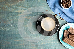 Breakfast with delicious wafers and coffee on blue wooden table, flat lay. Space for text