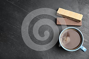 Breakfast with delicious wafers and cup of coffee on table, flat lay. SPace for text