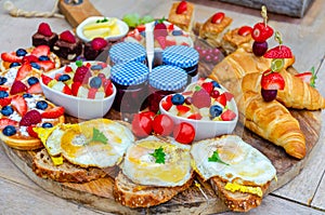 Breakfast eating concept with various morning food placed on a wooden plate.