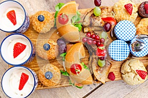 Breakfast eating concept with various morning food placed on a wooden plate.