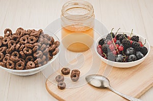 Breakfast with flakes, berries, honey/breakfast with flakes, berries, honey on a wooden tray