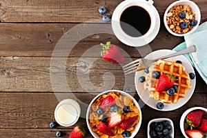 Breakfast food corner border. Fruits, cereal, waffles, milk and coffee. Top view over wood with copy space.