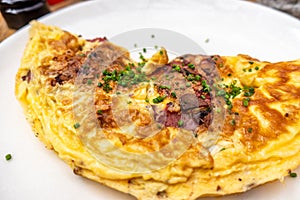 Breakfast food - Omelette with meat, cheese, onion on the white plate