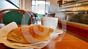 Breakfast in the foreground, brioche and cup of coffee, breakfast