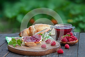 Breakfast with fresh roll and raspberry jam
