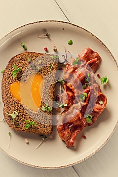 Breakfast, fried egg with bacon, micro-green, on a light background, no people, selective focus,