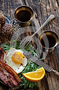 Breakfast with fried egg and becon in rustic stile