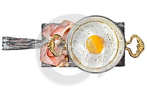 Breakfast with fried egg in a skilet with tomatoes and bacon. Isolated, white background.