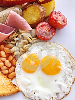 Breakfast with fried eggs, bacon, toast and coffee on wooden table