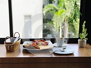 Breakfast with fried eggs, bacon, toast and coffee on wooden table