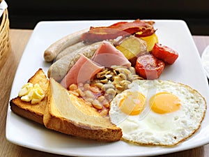 Breakfast with fried eggs, bacon, toast and coffee on wooden table