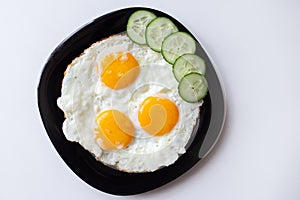 Breakfast. Fried eggs with bread and cucumbers