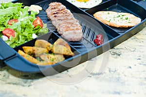 Breakfast, fried steak or cutlet, salad with tomato and green vegetables, toast, potato, egg close-up, light background, copy