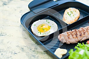 Breakfast, fried steak or cutlet, salad with tomato and green vegetables, toast, potato, egg close-up, light background