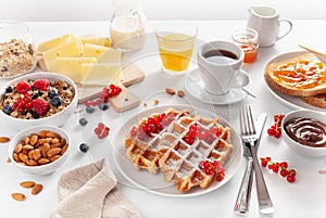 Breakfast with granola berry nuts, waffle, toast, jam, chocolate spread and coffee