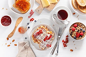 Breakfast with granola berry nuts, waffle, toast, jam and tea.
