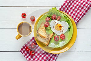 Breakfast with heart-shaped fried egg, toast, cherry tomato, let