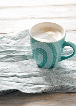 Breakfast idea. Cup with coffee on linen napkin and wooden background