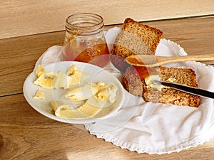 Breakfast with integral toast, butter and apricot jam on wooden table photo
