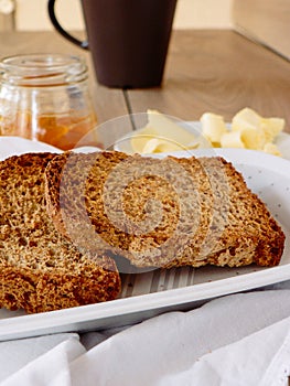 Breakfast with integral toast, butter and apricot jam on wooden table photo