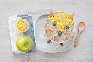 Breakfast for kids, oatmeal porridge with fruits and green apple