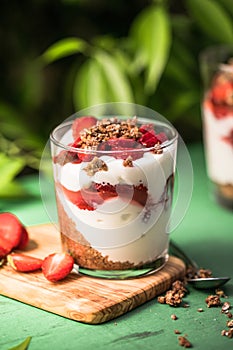 Breakfast layered parfait dessert with yogurt, sponge biscuit and fresh strawberry, white background copy space