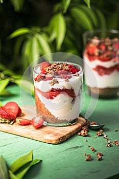 Breakfast layered parfait dessert with yogurt, sponge biscuit and fresh strawberry, white background copy space