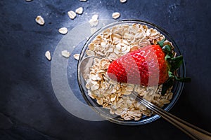 Breakfast made up of dry cereal with red strawberries