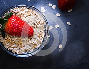 Breakfast made up of dry cereal with red strawberries