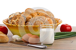 Breakfast menu - fresh buns, milk, eggs and tomatoes