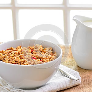 Breakfast Muesli cereal clusters with a jug of fresh milk.