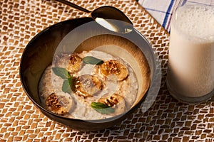Breakfast oatmeal porridge bowl with banana and caramel, close-up