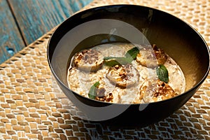 Breakfast oatmeal porridge bowl with banana and caramel, close-up