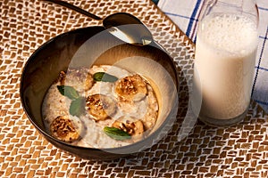 Breakfast oatmeal porridge bowl with banana and caramel, close-up