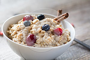 Breakfast oatmeal porridge with cinnamon, cranberries and blueberries