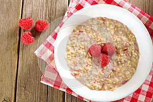 Breakfast oatmeal with raspberries overhead view